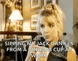 a woman is drinking a cup of dunkin 's coffee while talking on a phone .