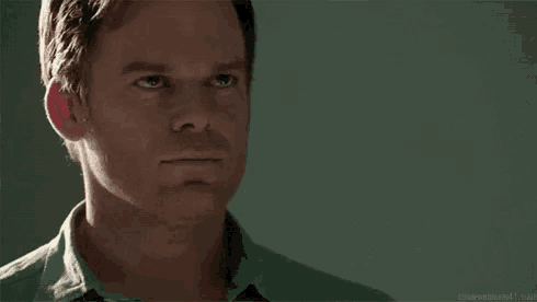 a close up of a man 's face with a green shirt and tie .