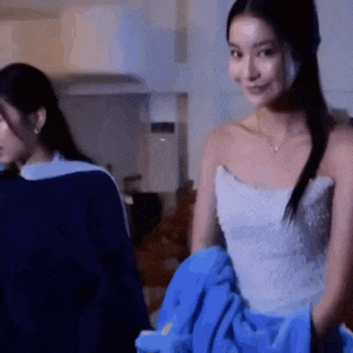 a woman in a white dress is standing next to another woman .