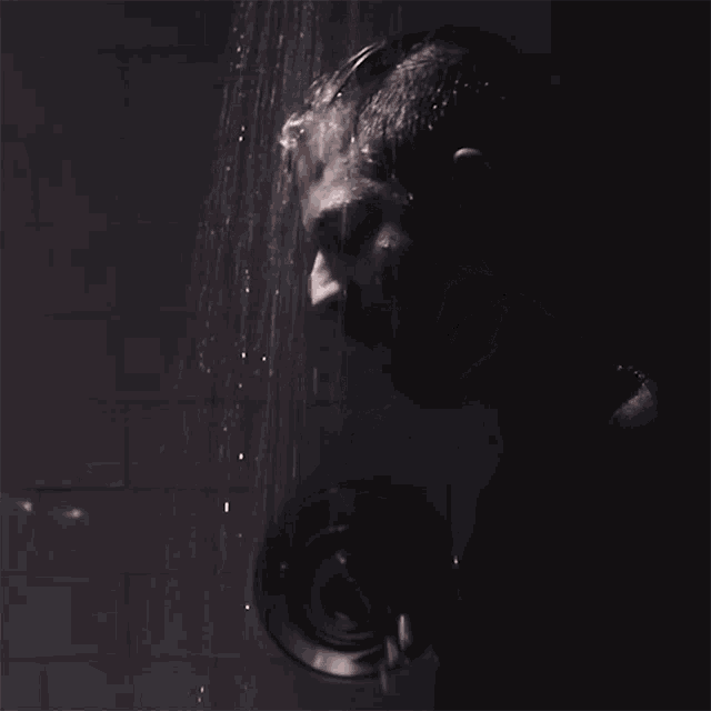a man taking a shower with water coming out of his head