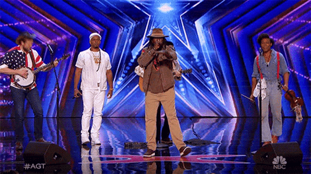 a group of men are performing on a stage with a nbc logo in the corner