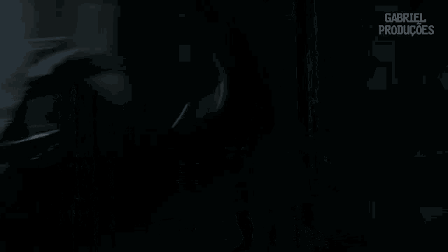 a man holding a sword in a dark room with the words gabriel producoes on the bottom right