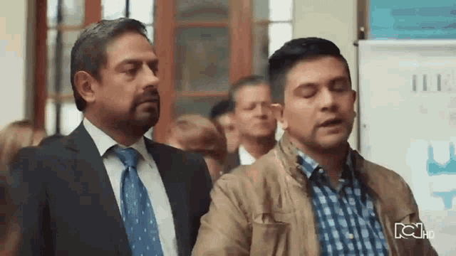 two men in suits and ties are standing next to each other