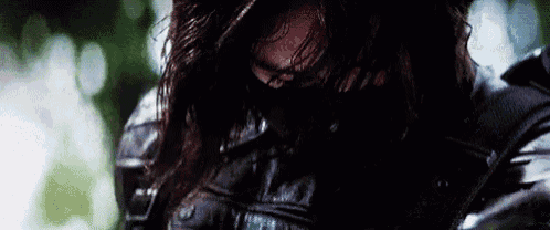 a close up of a person wearing a leather jacket with a mask on their face .