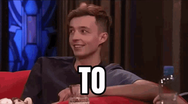 a man sits on a couch with the words samozrejme written on the screen