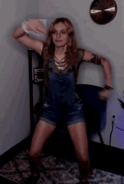 a woman in overalls dancing in front of a clock