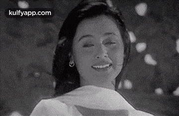 a black and white photo of a woman smiling .