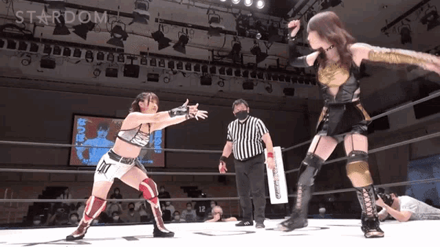 two women wrestling in a ring with the word stardom on the wall
