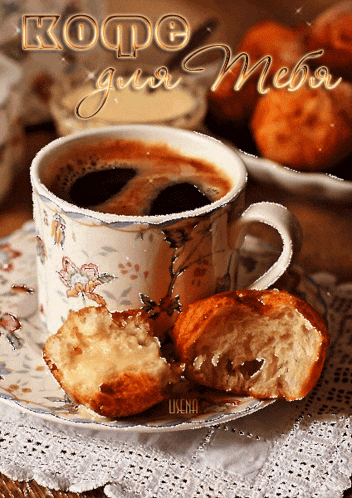a cup of coffee sits on a saucer next to a bite taken out of a croissant