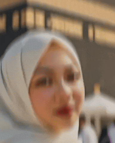 a woman wearing a white hijab is looking at the camera .