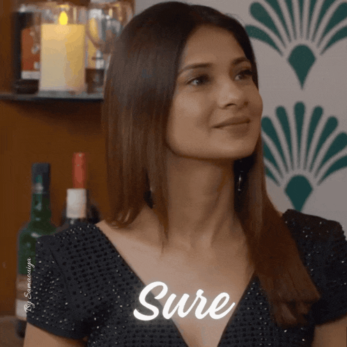 a woman in a black dress is smiling with the word sure written on her chest