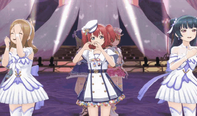 a group of anime girls are standing on a stage and one of them is making a heart shape with her hand