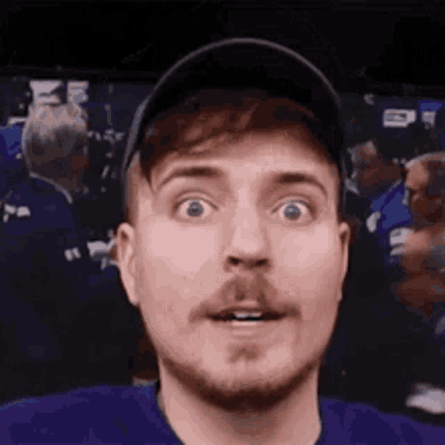 a man with a beard wearing a hat is making a funny face .