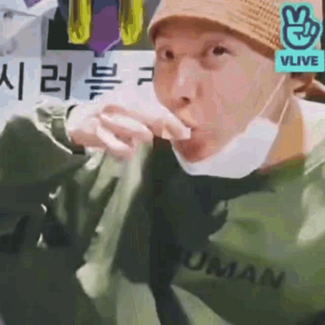 a close up of a person wearing a mask and a hat eating something .