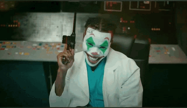 a man wearing a clown mask holds a walkie talkie in his hand