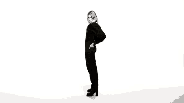 a woman in a black jumpsuit is standing in front of a white background .