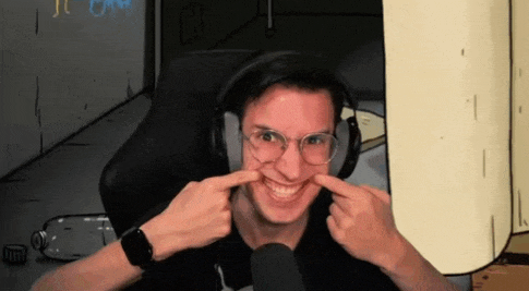 a man wearing headphones and glasses is making a funny face with his hands .