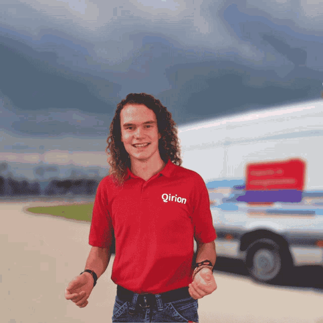 a man wearing a red qirion shirt stands in front of a van