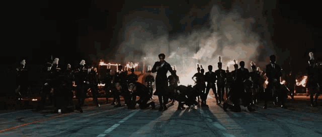 a group of people dancing in front of a fire