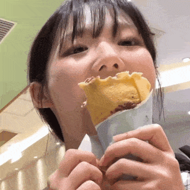 a young girl is eating an ice cream cone in a restaurant
