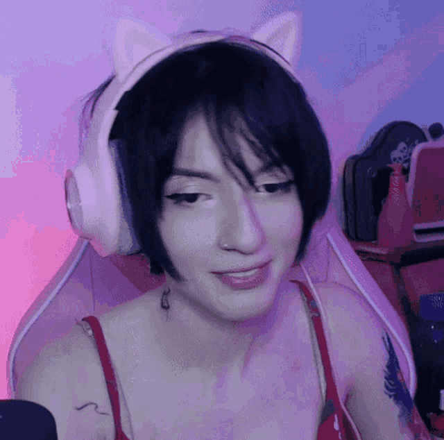 a woman wearing a pair of pink headphones with cat ears on her head .