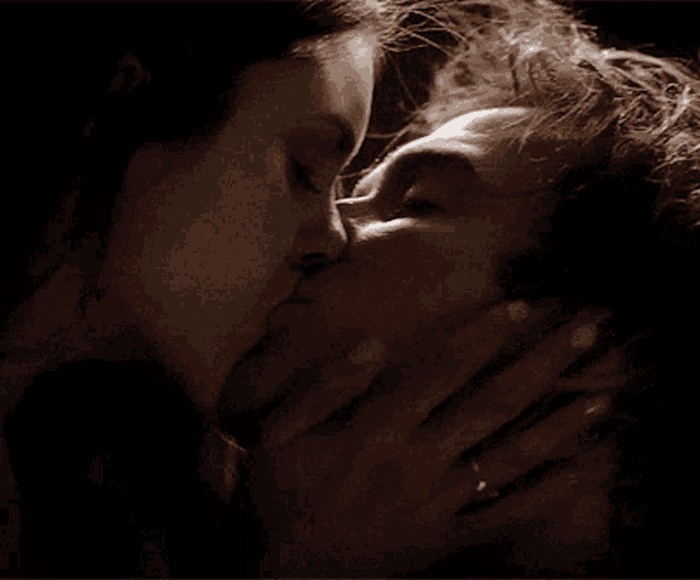 a man and a woman are kissing and the woman is wearing a ring