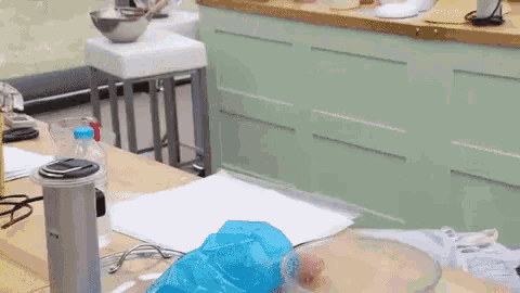 a kitchen counter with a bottle of water and a bowl on it