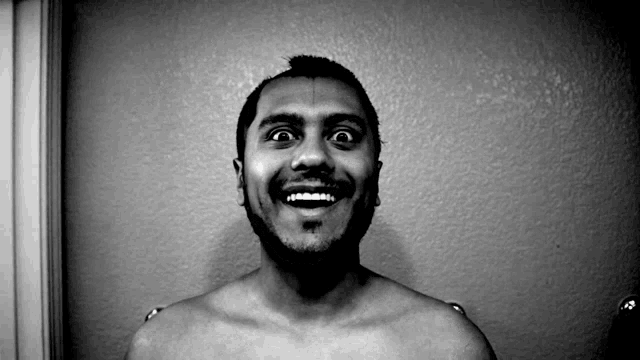 a man without a shirt is smiling and looking up at the camera