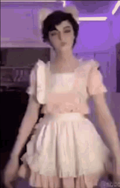 a man in a maid costume is standing in a room with purple lights .