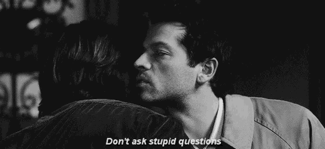 a black and white photo of a man hugging another man with the words " don 't ask stupid questions " on the bottom