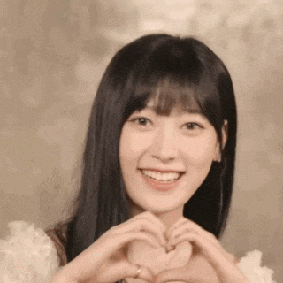 a woman is making a heart shape with her hands .