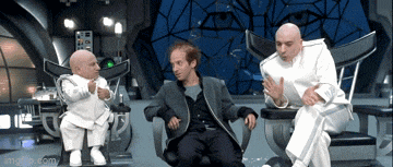 three men in white suits are sitting in chairs in front of a giant eye