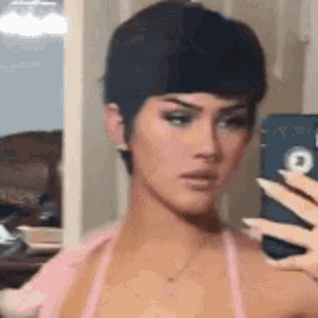 a woman is taking a picture of herself in the mirror .