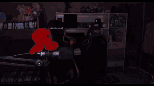 a man wearing headphones stands in front of a microphone with a red stuffed octopus in front of him
