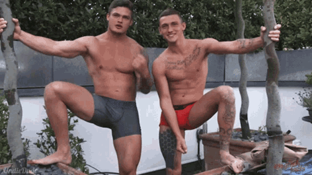 two shirtless men squatting next to each other with one of them having a tattoo on his chest that says ' loving you '