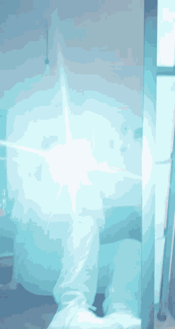 a person is standing in front of a mirror with a blue light coming out of it