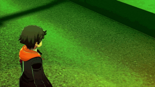 a person standing in a dark room with a green wall behind them