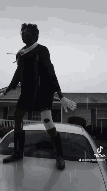 a person is standing on the hood of a car with a knee brace