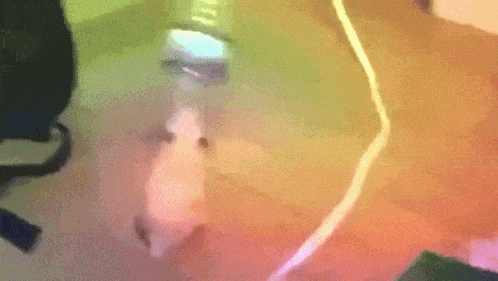 a blurred image of a person 's face with a rainbow colored background