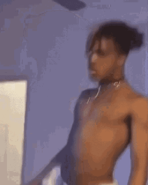a shirtless man is standing in a room .