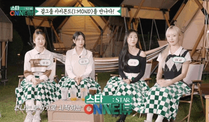 a group of girls are sitting in front of a tent with a sign that says star onneir on it