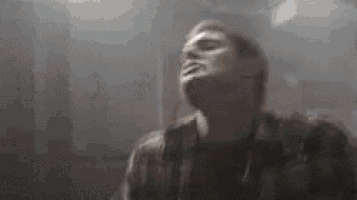 a man is standing in a dark room with his eyes closed and his head is visible .