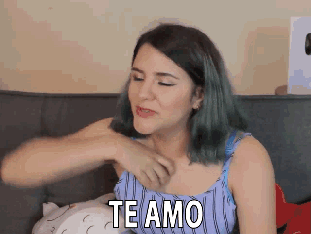 a woman with green hair is sitting on a couch saying te amo