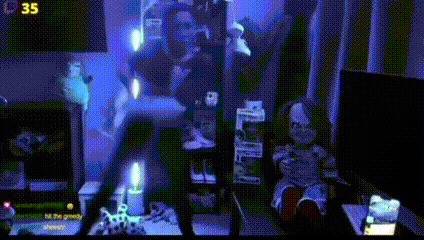 a doll is sitting on a table in a dark room with a candle in the foreground .
