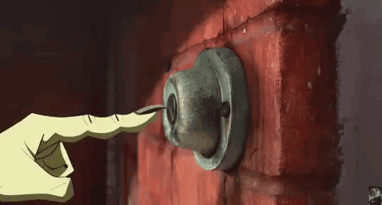 a person 's finger is pointing at a keyhole on a red brick wall