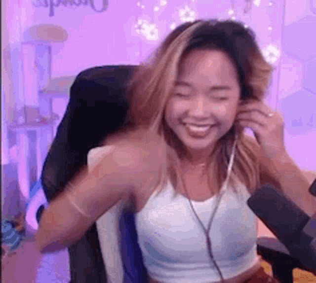 a woman is sitting in a chair in front of a microphone and smiling .