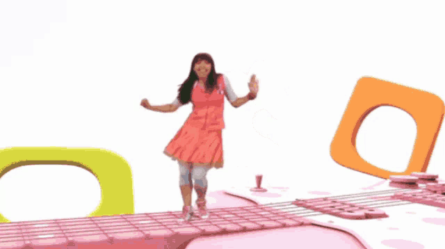 a girl in a pink dress is dancing on a pink platform