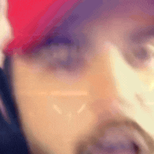 a close up of a man 's face wearing a hat and glasses .