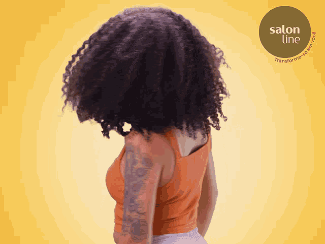 a woman with curly hair is standing in front of a salon line advertisement