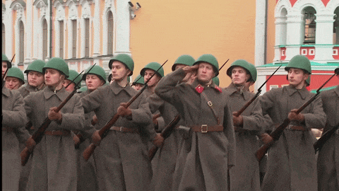 a group of soldiers salute in front of a building with the letter o on it